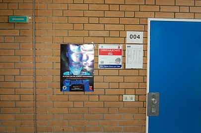 Hinweis auf die Verwendung von "Künstlicher DNA" an öffentlichen Gebäuden wie z. B. an Schulen.